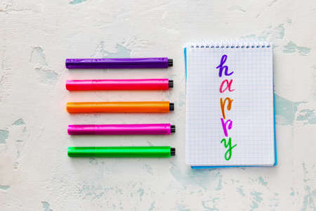 Notebook with word HAPPY and markers on light backgroundの写真素材