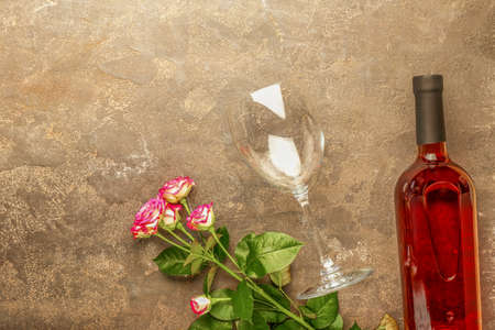 Bottle of wine, glass and roses on grunge backgroundの写真素材