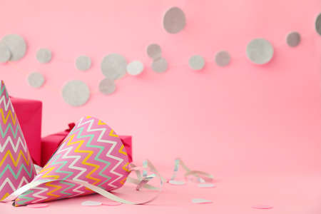 Party hats, gift and decor on color backgroundの写真素材