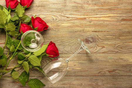 Wineglasses and roses on wooden backgroundの写真素材