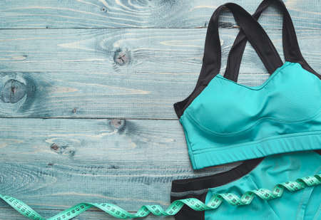 Sportswear and measuring tape on color wooden backgroundの写真素材