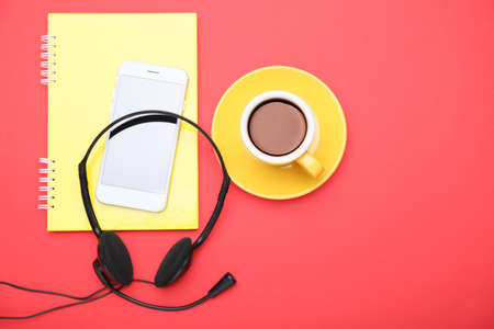 Notebook, mobile phone, headset and coffee on color backgroundの写真素材