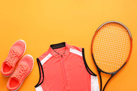 Sportswear and tennis racket on color backgroundの写真素材