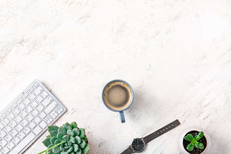 Cup of coffee with computer keyboard and clock on white backgroundの写真素材