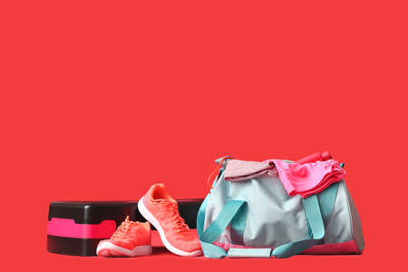 Bag with sportswear, equipment and shoes on color backgroundの写真素材
