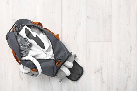 Bag with sportswear and equipment on wooden backgroundの写真素材