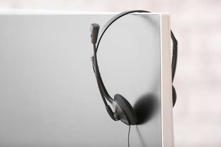 Headset hanging on monitor of technical support agent in office