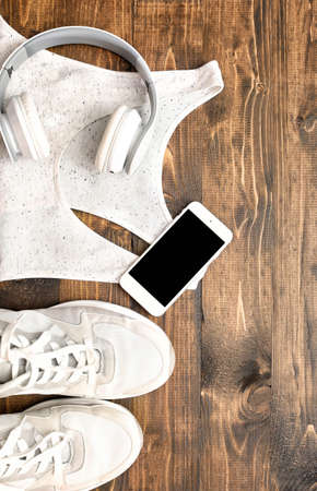 Sportswear, headphones and mobile phone on wooden backgroundの写真素材
