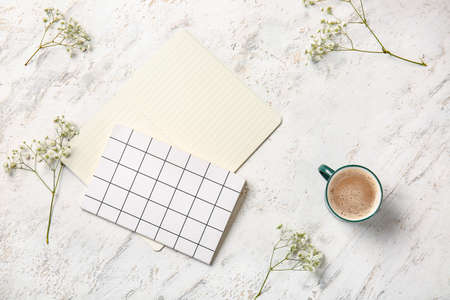 Cup of coffee with notebooks on white background