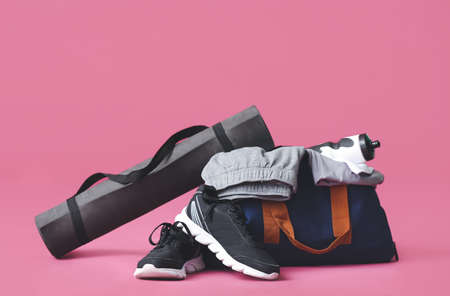 Bag with sportswear, equipment and shoes on color backgroundの写真素材
