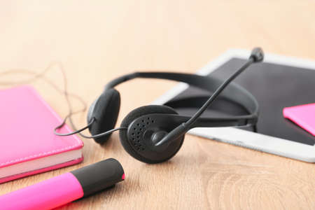 Headset, tablet computer and notebook on table of technical support agent in officeの写真素材
