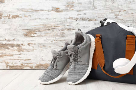 Bag with sportswear, equipment and shoes on wooden backgroundの写真素材