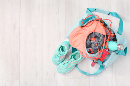 Bag with sportswear, equipment and shoes on wooden backgroundの写真素材