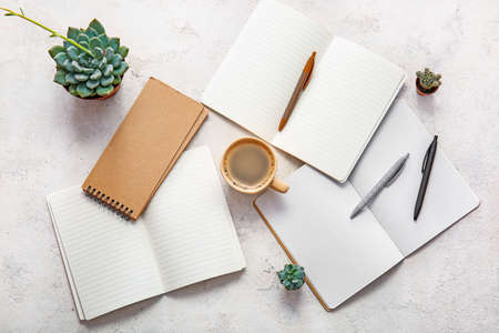 Cup of coffee with notebooks on white backgroundの写真素材