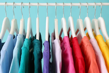 Rack with hanging clothes on color background, closeupの写真素材