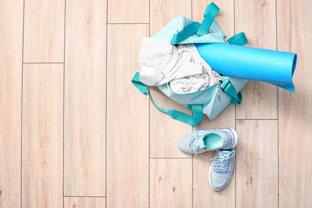 Bag with sportswear, equipment and shoes on wooden backgroundの写真素材
