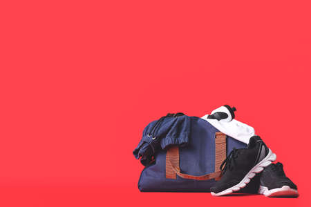 Bag with sportswear, equipment and shoes on color backgroundの写真素材