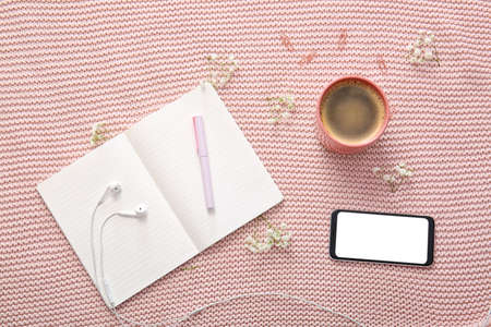 Notebook with mobile phone and cup of coffee on color backgroundの写真素材