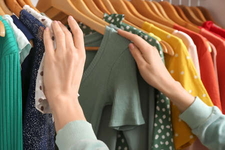 Woman choosing clothes from wardrobe at home, closeupの写真素材