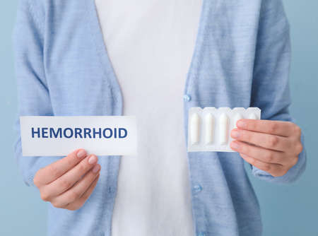 Woman with hemorrhoidal suppositories on color backgroundの写真素材