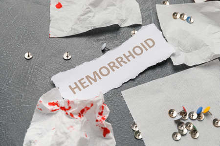 Paper with word HEMORRHOID and thumbtacks on gray backgroundの写真素材