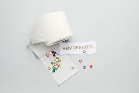Toilet paper with thumbtacks on light background. Hemorrhoids conceptの写真素材