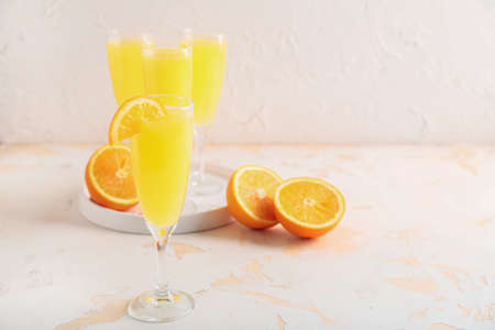 Glass of tasty mimosa cocktail on white tableの写真素材