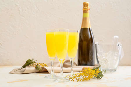 Glasses of tasty mimosa cocktail on white tableの写真素材