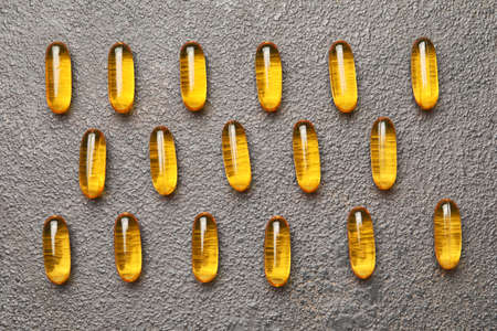 Fish oil capsules on gray background