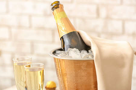 Bucket with bottle and glasses of champagne in restaurantの写真素材