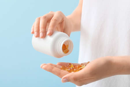 Woman with fish oil capsules, closeupの写真素材