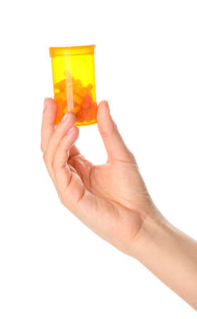 Female hand holding bottle of pills on white backgroundの写真素材