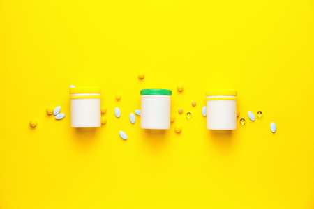 Bottles with pills on color background