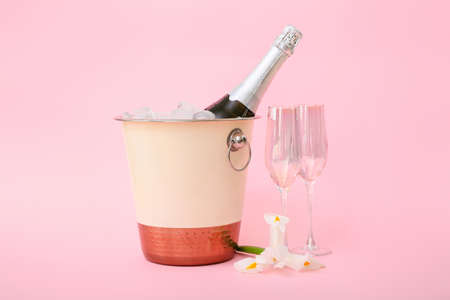 Bucket with ice and champagne on color backgroundの写真素材