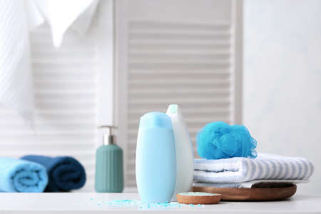 Shower gels, towels, sea salt and loofah in bathroomの写真素材