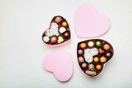 Heart-shaped boxes with delicious candies on white backgroundの写真素材