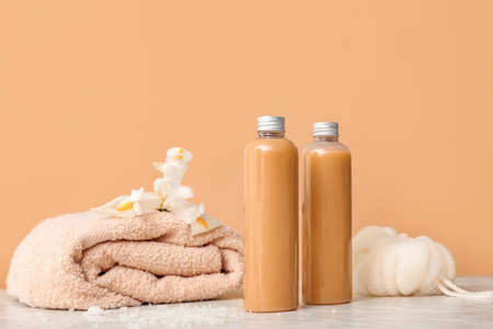 Shower gels, towel and loofah on color backgroundの写真素材