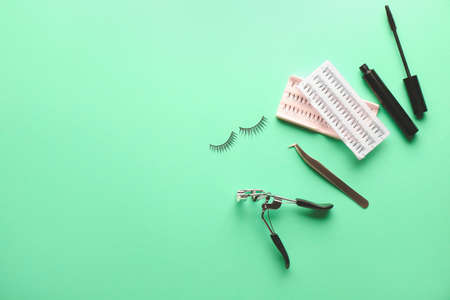 Mascara, eyelash extensions, tweezers and curler on color backgroundの写真素材
