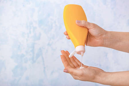 Female hands with shower gel on light backgroundの写真素材