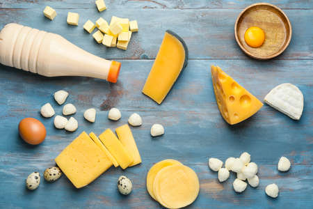 Different dairy products on color wooden background