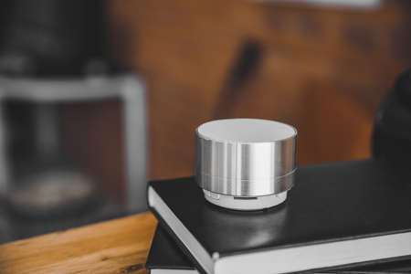 Smart home assistant device with books on table in roomの写真素材
