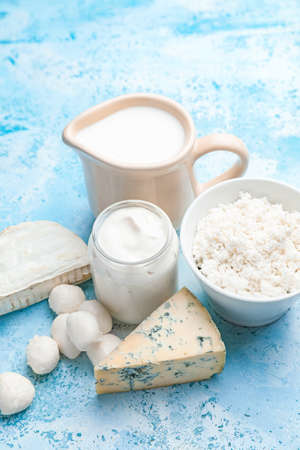 Different dairy products on color background