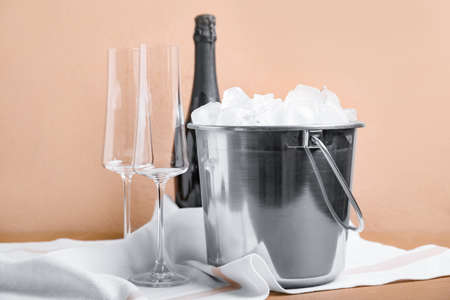 Bucket with ice and champagne on color backgroundの写真素材
