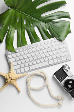 Computer keyboard with photo camera, rope and starfish on white backgroundの写真素材
