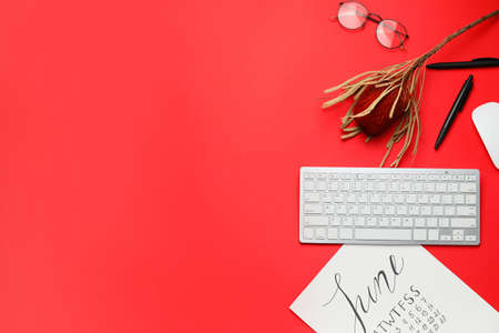 Computer keyboard with calendar and stationery on color backgroundの写真素材