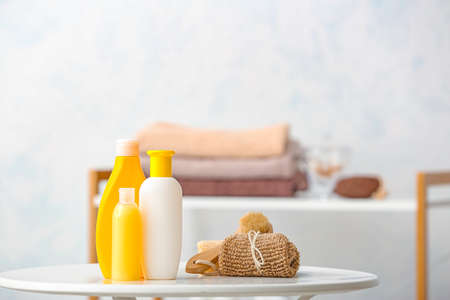 Different shower gels and towel on table in bathroomの写真素材