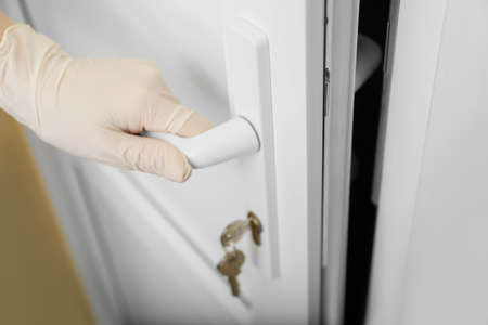 Woman in protective gloves opening door, closeup