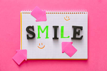 Notebook with word SMILE on color backgroundの写真素材