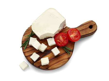 Board with tasty cut feta cheese on white backgroundの写真素材