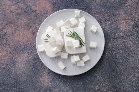 Plate with tasty cut feta cheese on tableの写真素材